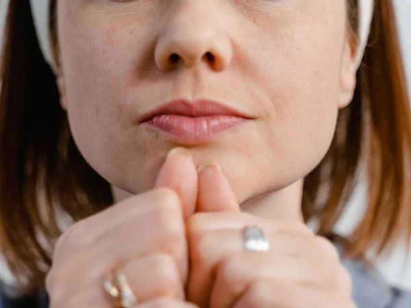 Close-up of a woman's serene face with eyes closed in meditation.